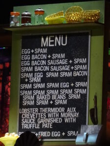 Café menu, listing various food options, almost all of which include Spam.